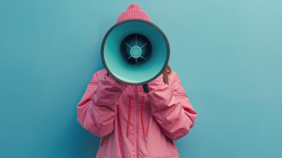 Femme tenant un hait parleur qui lui cache son visage